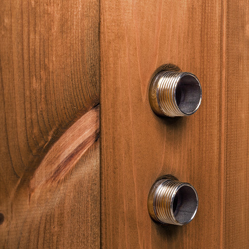 Close-up of metal water filter connectors installed on natural wood panel with visible grain texture