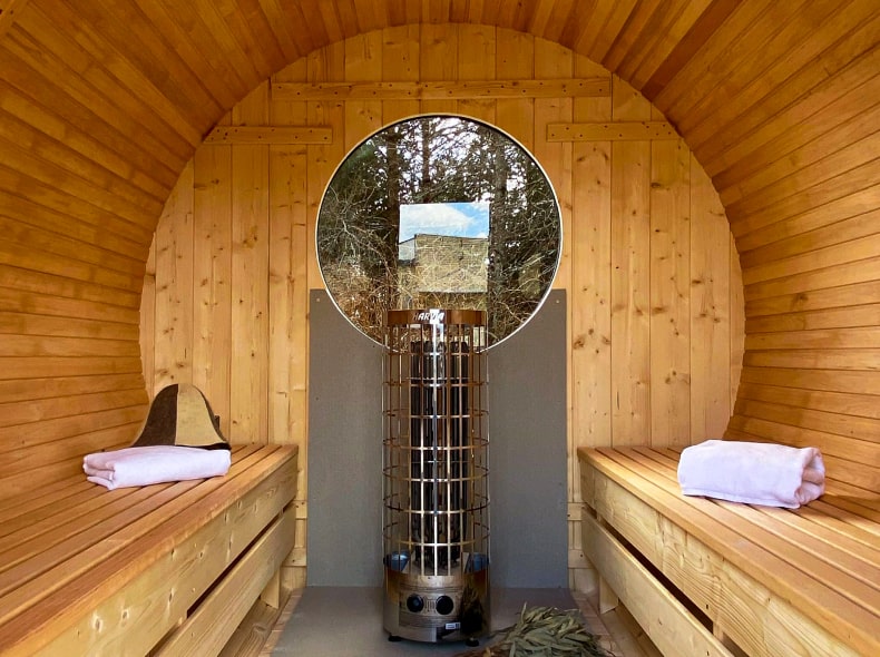 Showcasing the inside of a wooden barrel sauna.