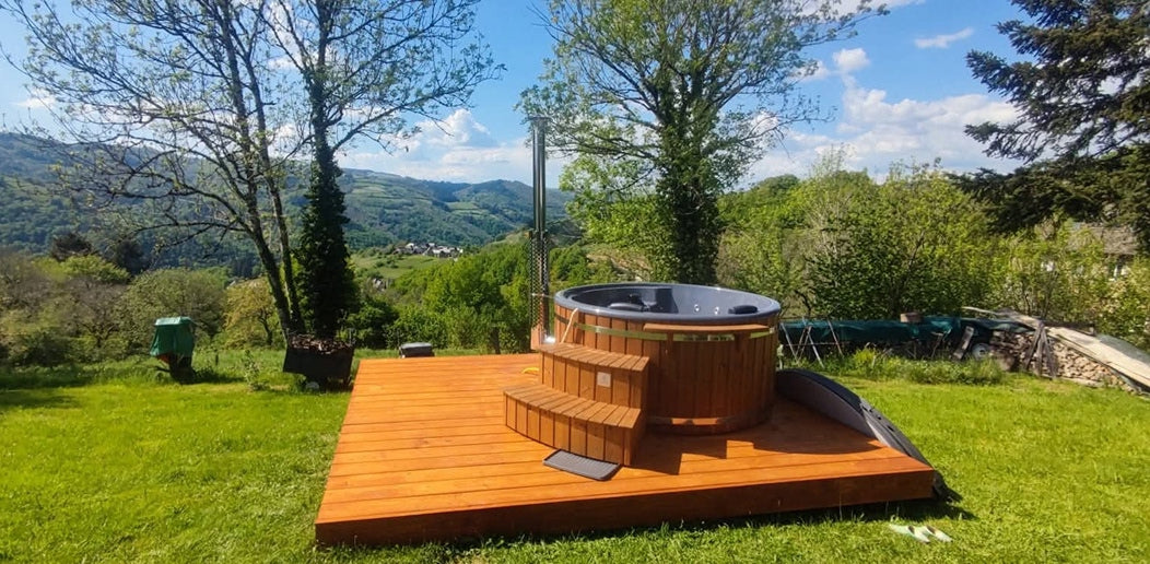 A round hot tub on the terrace, set amidst the stunning grandeur of nature in a mountainous landscape