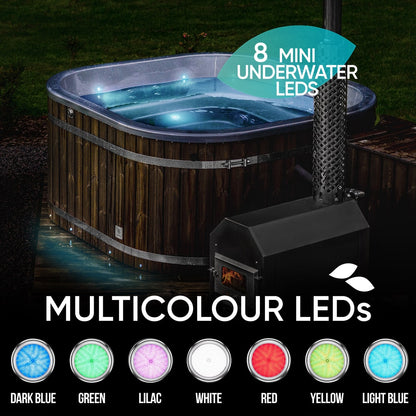 Evening view of a square wood fired hot tub with external stove and multicolour underwater LED lights illuminated