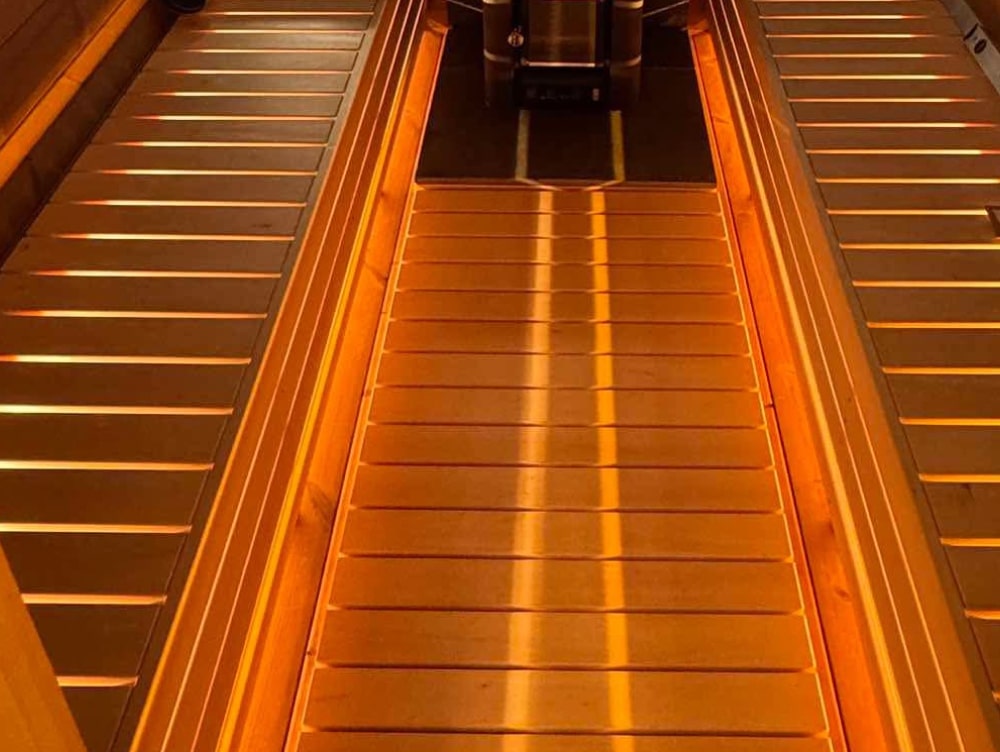Close-up view of wooden slatted flooring with warm lighting in an indoor setting