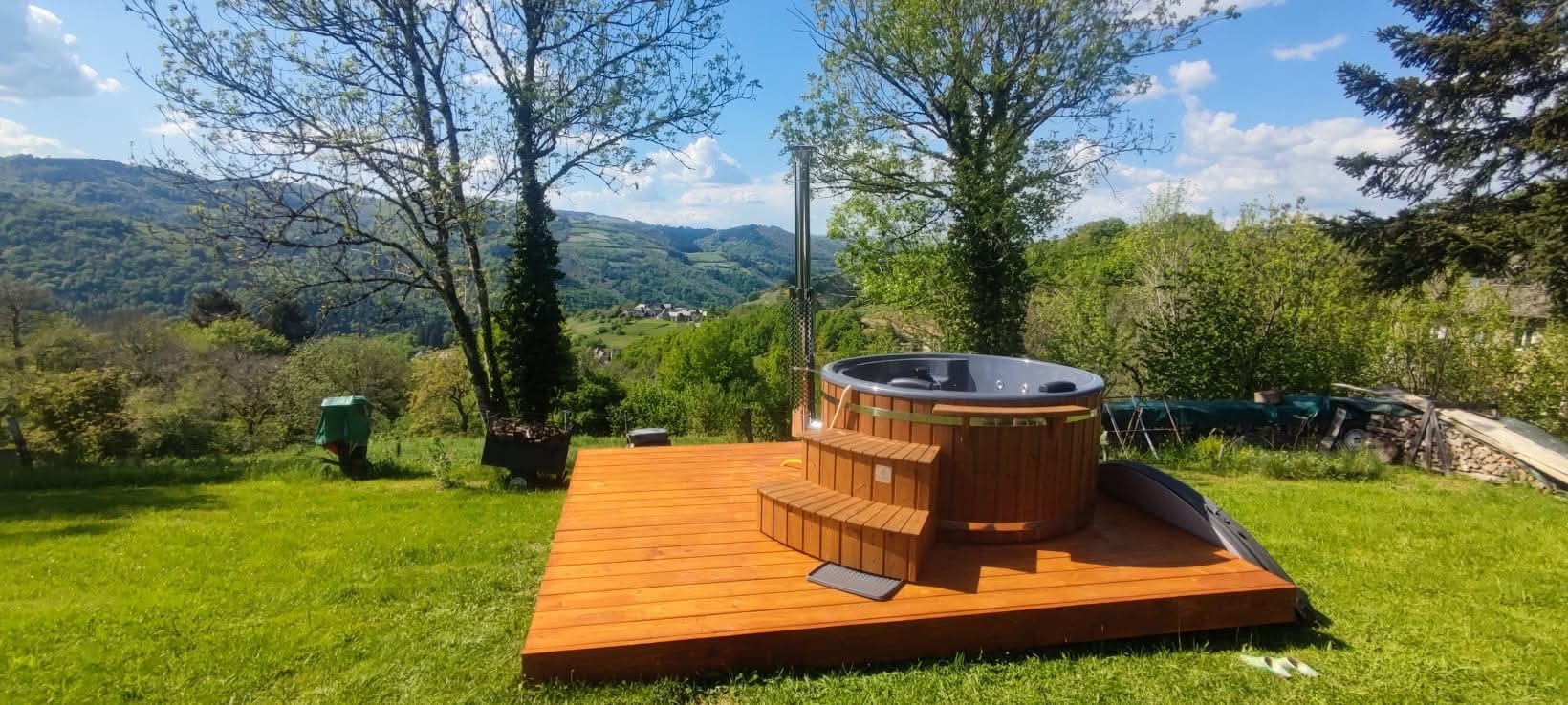 Round Gardenvity hot tub on wooden deck in a countryside garden in France – real customer photo